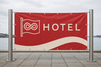Banner mit eigenem Design, straff zwischen zwei Stahlpfosten gespannt, mit Ösen ringsum